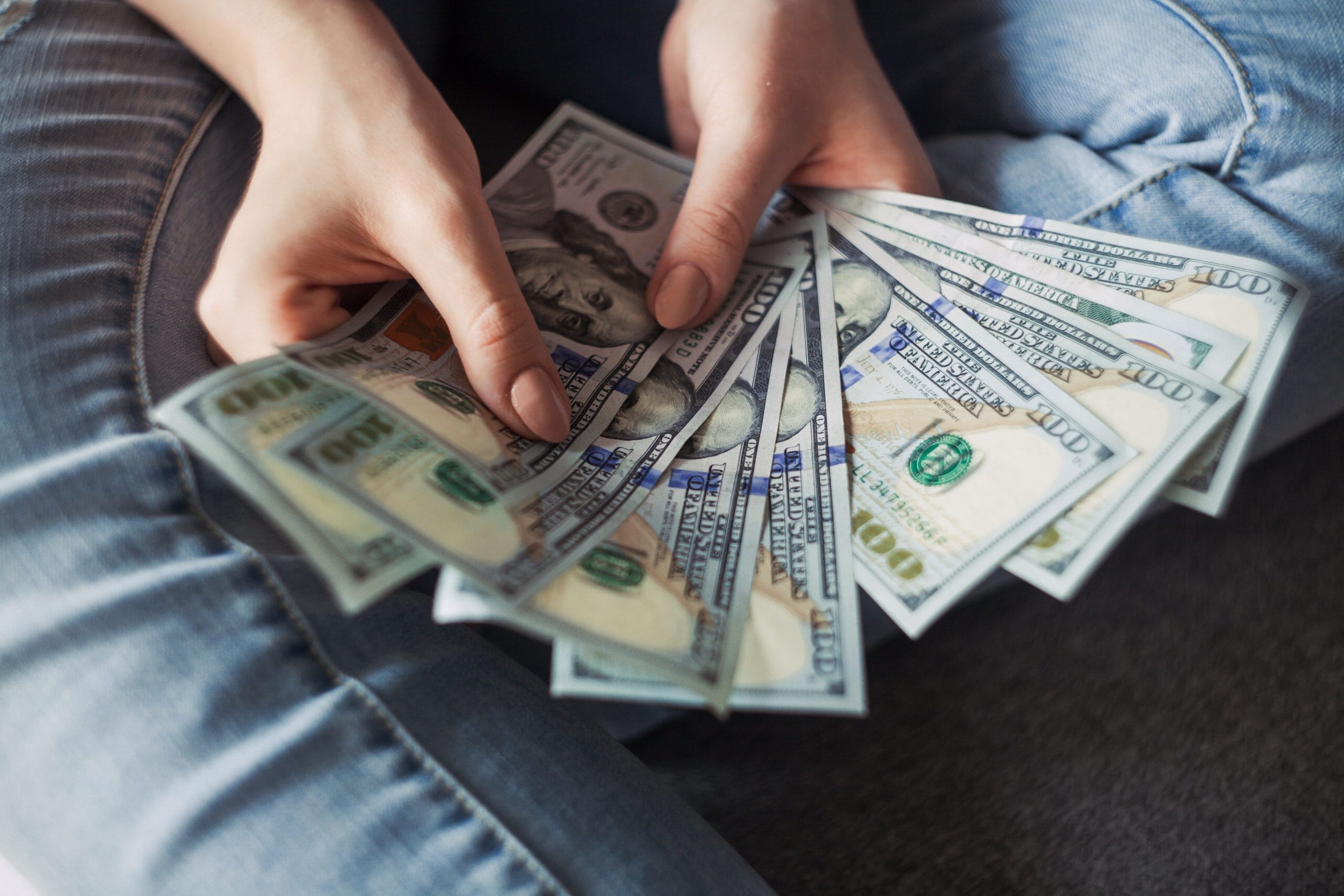 Eine Frau hält während eines Startup-Coachings einen Haufen Geld in den Händen.