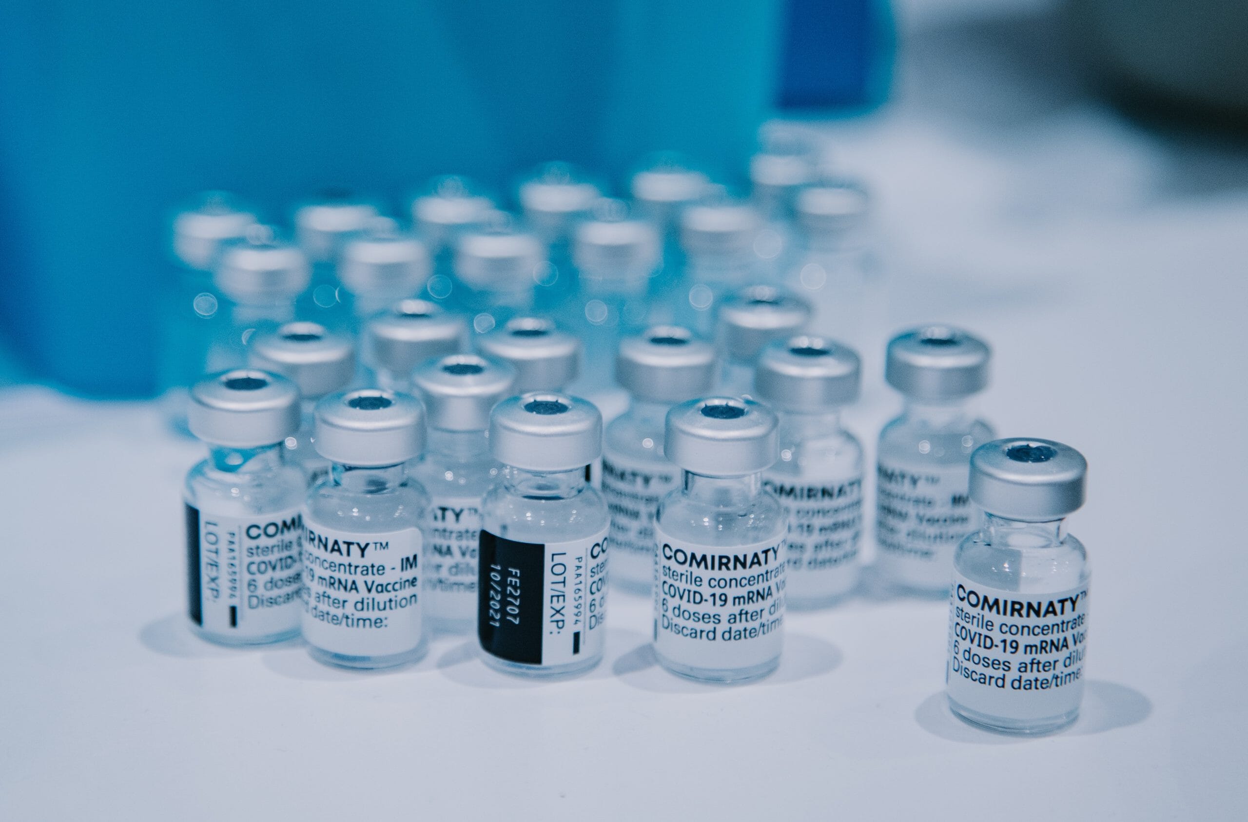Coronavirus-Impfstoffe auf einem Tisch neben einem blauen Behälter in einem Startup-Büro.