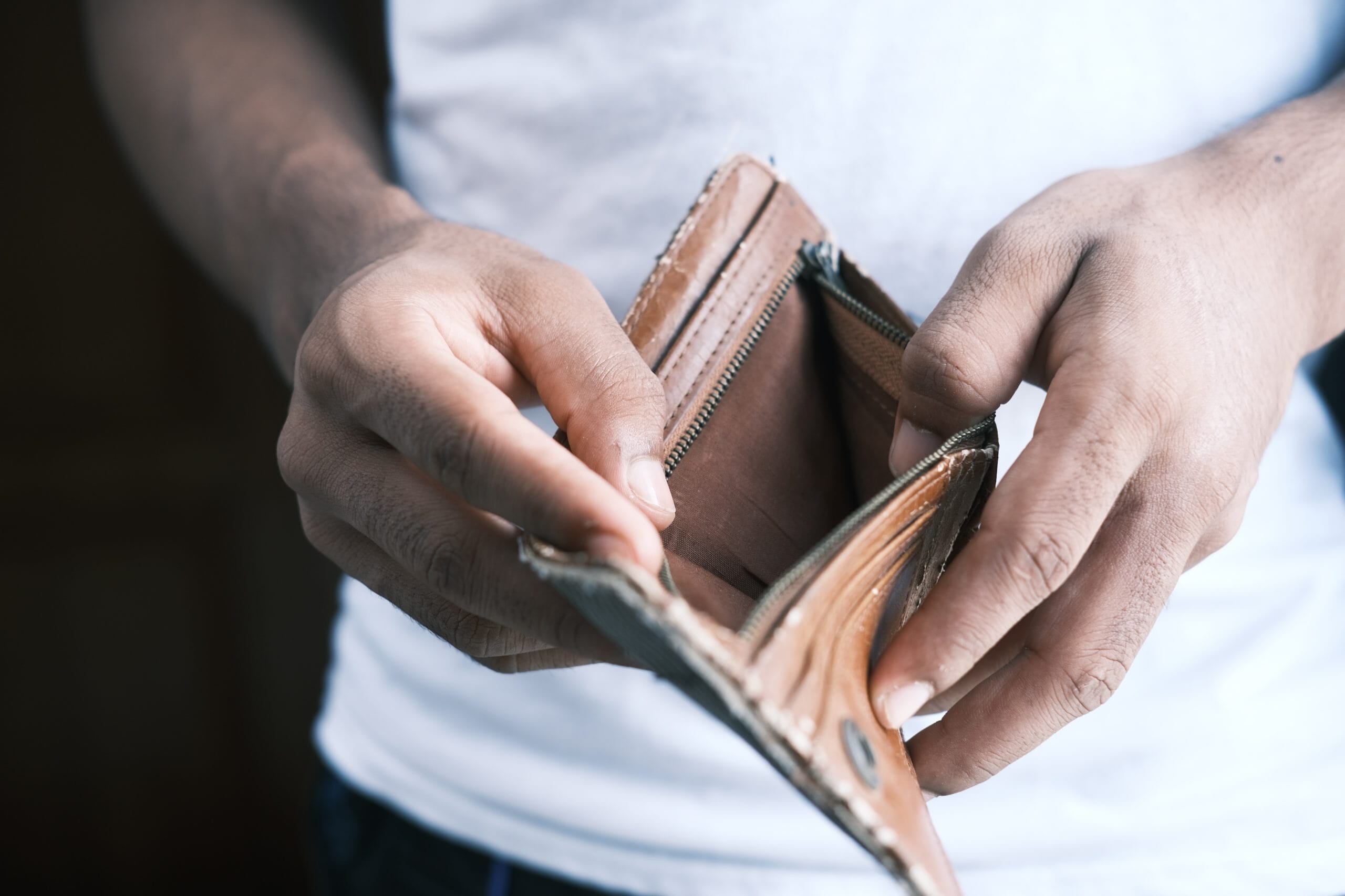 Die Hände eines Mannes halten eine leere Brieftasche und suchen Startup-Rat.