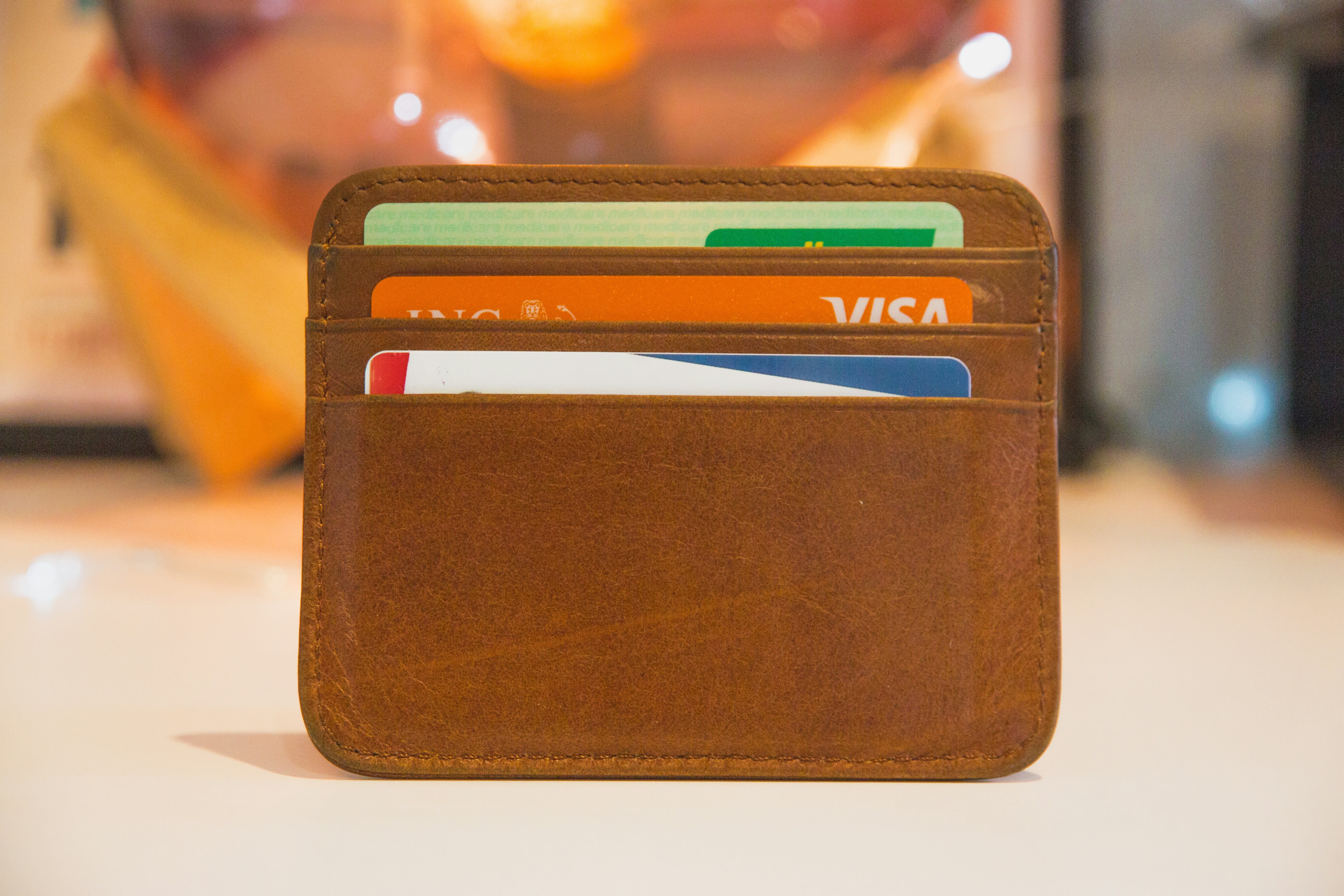 Ein braunes Kreditkartenetui aus Leder auf einem Tisch in einem Startup-Büro.